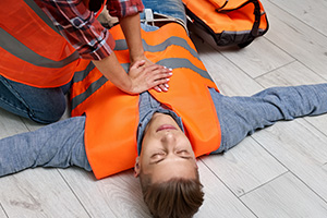 A first responder providing first aid care for a casualty.
