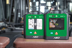 The St John Ambulance HEART One and HEART Two defibrillators on a table inside of a gym.