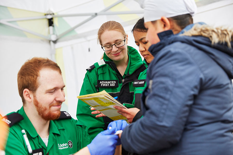 Volunteer treating patient's finger.